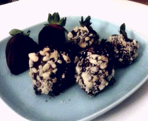 Strawberries dipped in chocolate and sprinkled with toasted brazil nuts